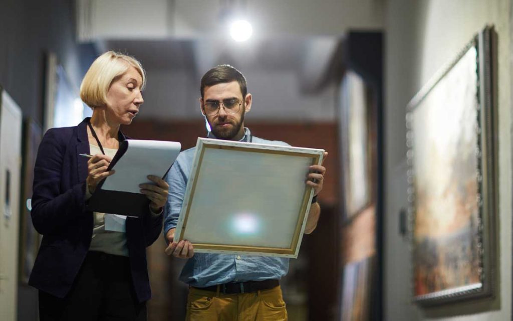 man and woman authenticating a painting