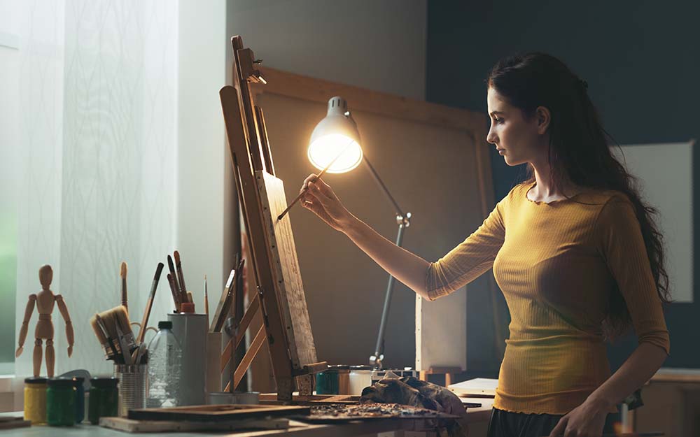 Creative woman painting on canvas in the studio